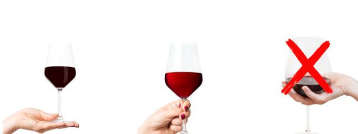 κρατήστε σωστά ένα ποτήρι κόκκινο κρασί